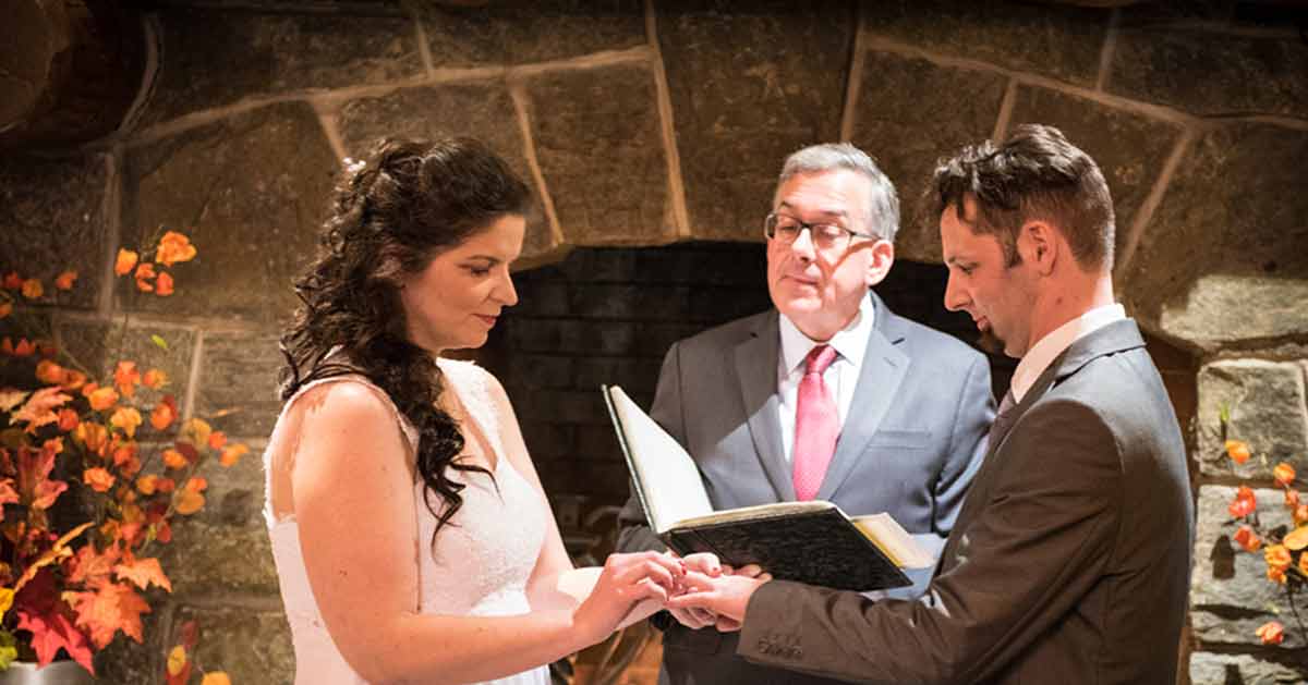 A couple says their vows in front of a fireplace at Whiteface Lodge.